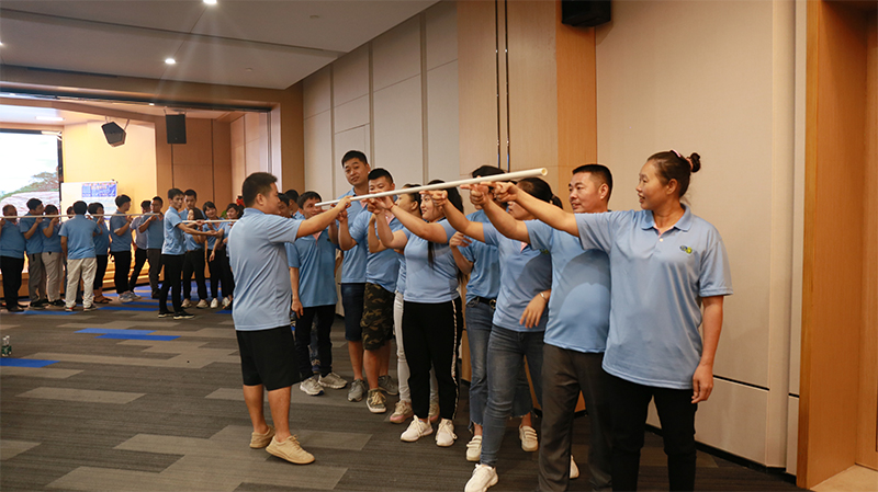 Team members participating in the Same Heart Rod game, emphasizing teamwork and collaboration.